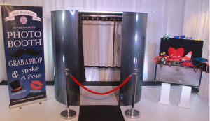 Enclosed photo booth with black carpet and box of props